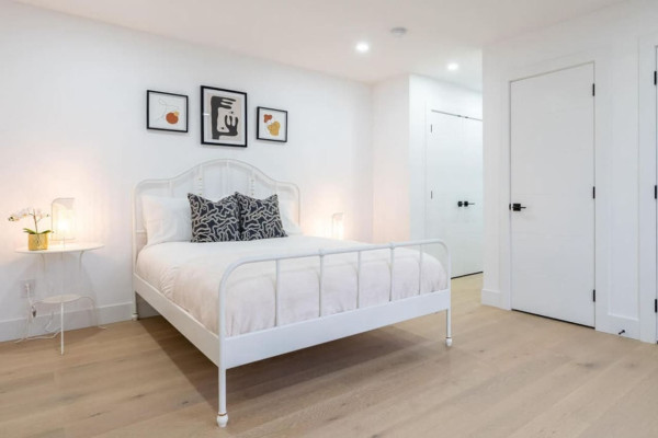 This serene third bedroom features a plush queen bed, soft lighting, and minimalist décor that invites total relaxation. With its bright, airy ambiance and modern finishes, it offers guests a peaceful retreat to unwind and recharge during their Vancouver