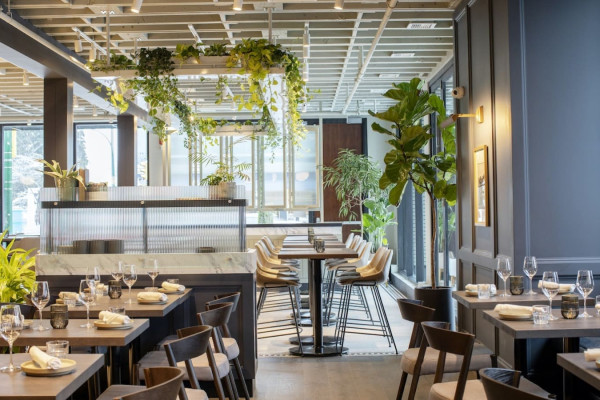 Bright and inviting dining space featuring modern furnishings and lush greenery — the perfect spot to enjoy a relaxed meal or gather with friends during your Vancouver stay.